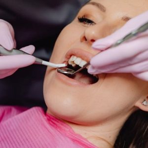 female in dental chair getting teeth cleaned