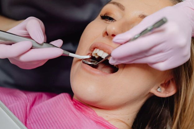 female in dental chair getting teeth cleaned