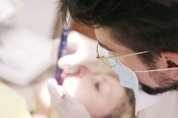 male dentist working in patient's mouth