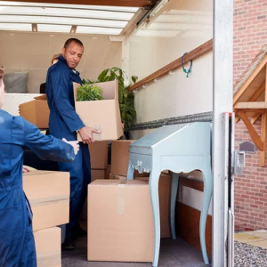 two men moving boxes from truck to home