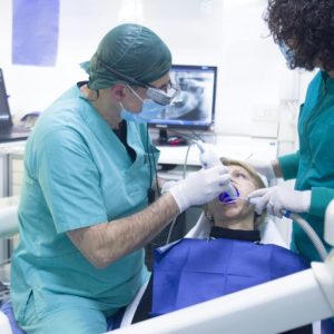 dentist and dental assistant doing oral surgery