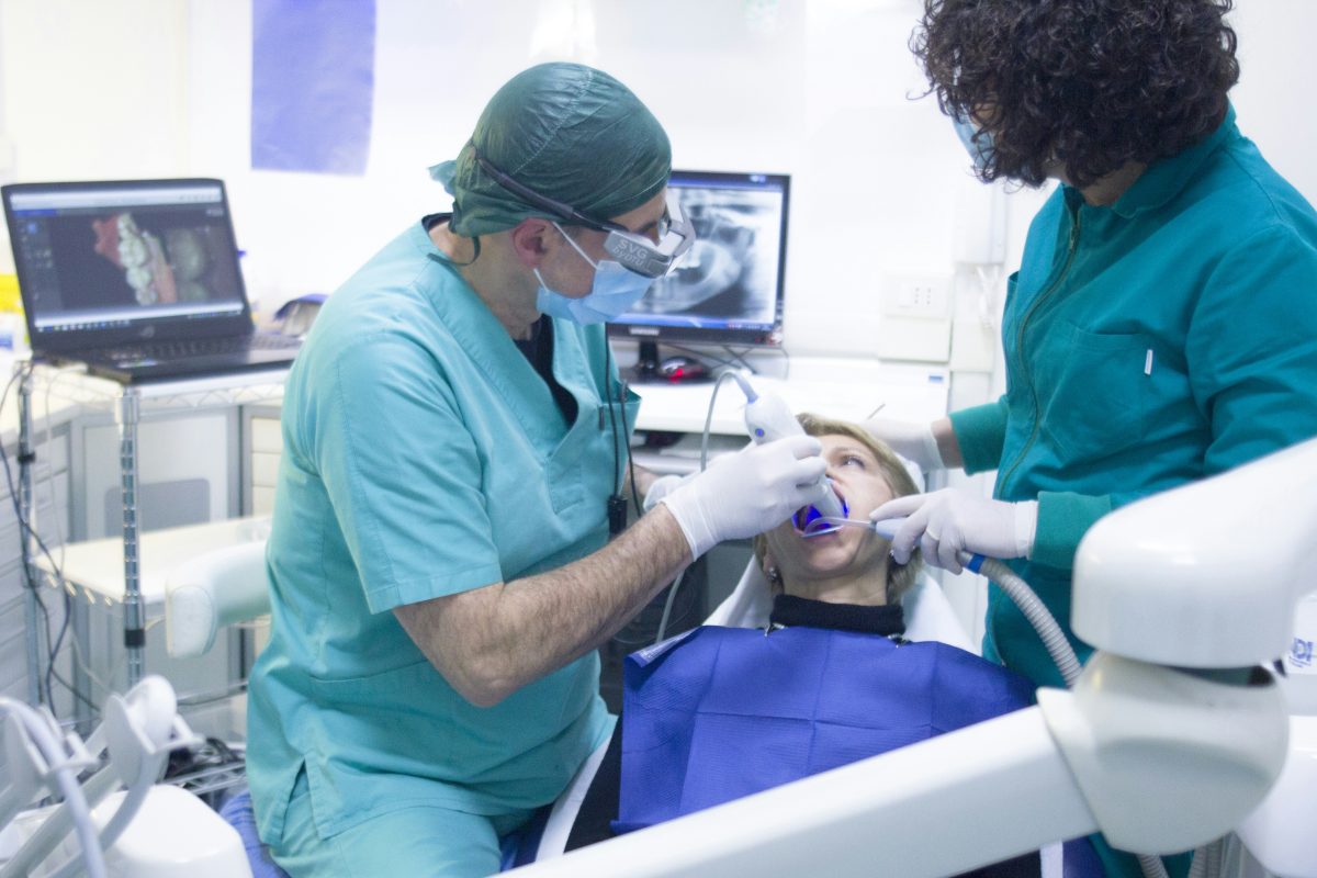 dentist and dental assistant doing oral surgery