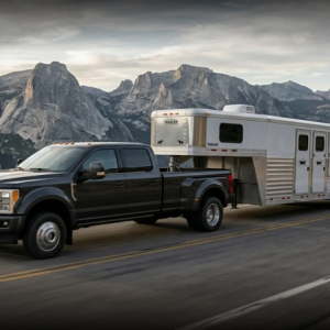 truck carrying trailer on open road with mountains