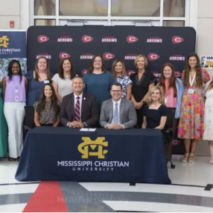 Mississippi Christian University (MC) President Blake Thompson, seated second from right, and Clinton Public School District (CPSD) Superintendent Andy Schoggin, seated second from left, sign the Rising Educator and Arrow Partnership (REAP) agreement on July 30 at Clinton’s Northside Elementary School. Joining them are Mandy Ambrose, seated left, Northside Elementary School principal; Stephanie Busbea, seated right, MC interim provost; and standing directly behind them from left, Jessica Crawley, Northside Elementary School assistant principal, Brittany Ricker, second from left, MC assistant professor of TEL and director of field experience; Rachel Peeples, second from right, chair of MC’s Teacher Education and Leadership program; and Martha D’Amico, right, interim dean of the MC School of Education and Human Science. The group is surrounded by MC students in the first REAP cohort.