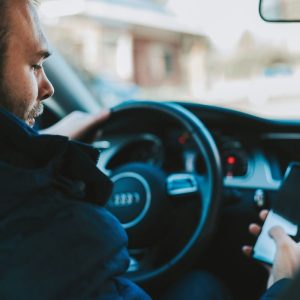 man looking at phone while driving