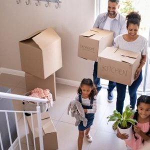 couple with children move boxes into a new home