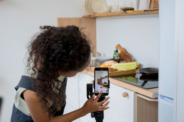 lady in the kitchen pressing button on her phone camera