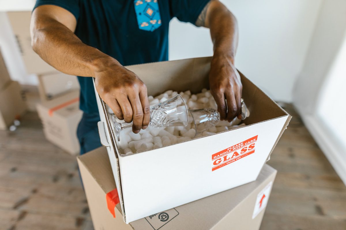 man putting glassware into moving box