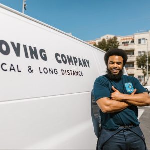 man standing beside moving van
