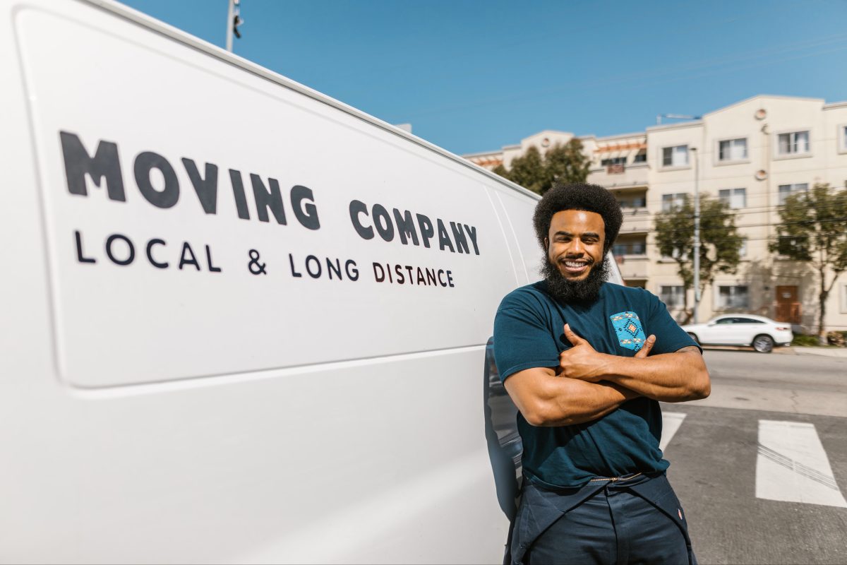 man standing beside moving van