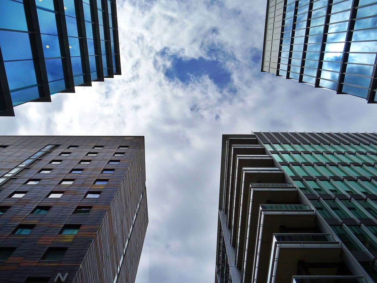 photo of tall buildings while looking up from the street