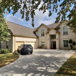home with new roof and a car parked in the driveway