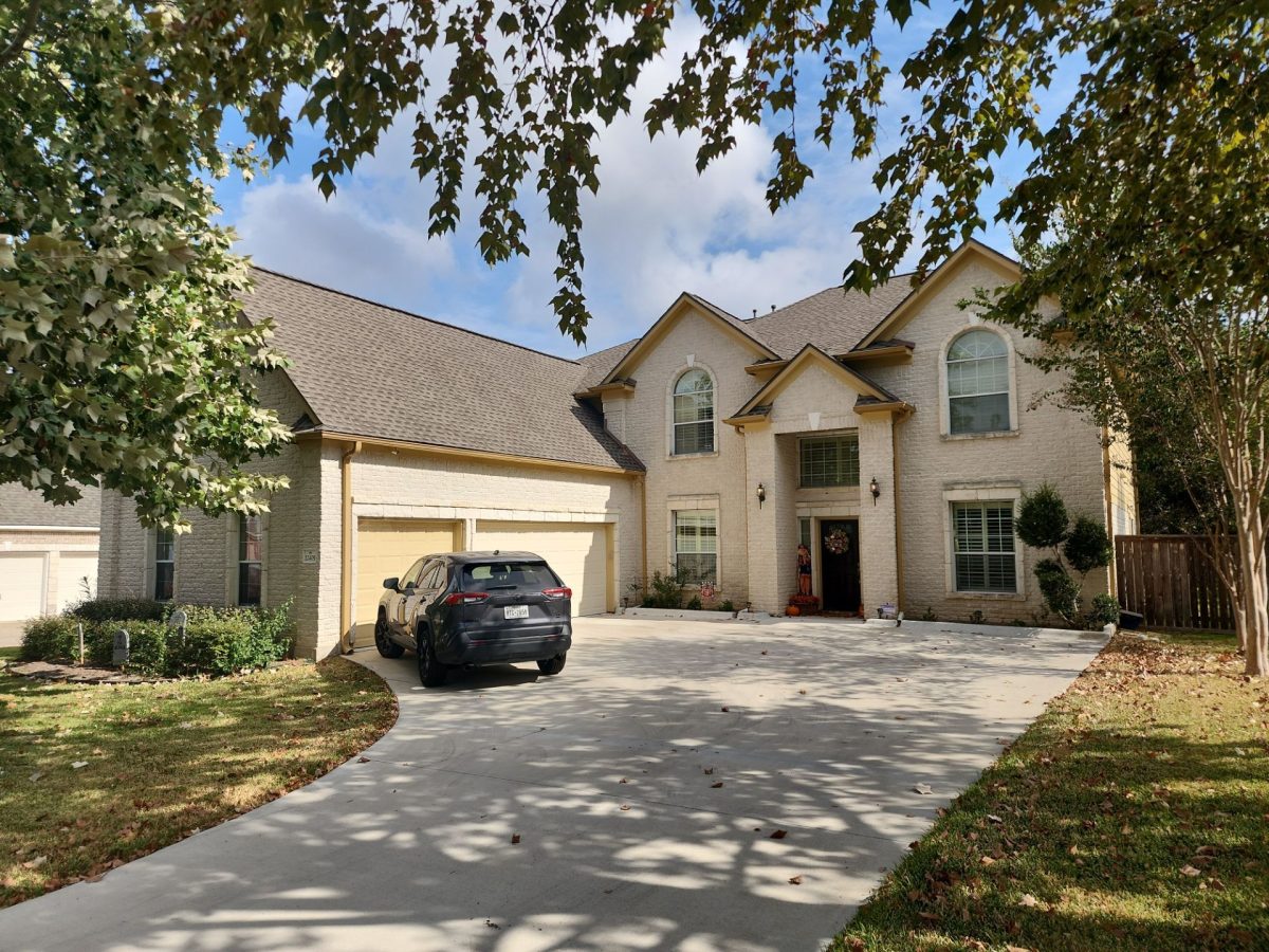  home with new roof and a car parked in the driveway