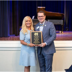 Mississippi Christian University President Blake Thompson presents a plaque to Carol Lee, conferring her new title as MC Professor Emerita of Kinesiology. Lee is one of five MC faculty to receive emeritus status from the University this year.