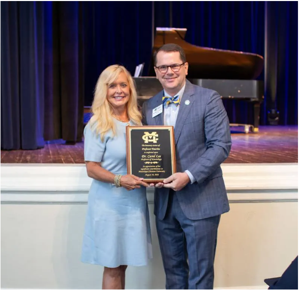 Mississippi Christian University President Blake Thompson presents a plaque to Carol Lee, conferring her new title as MC Professor Emerita of Kinesiology. Lee is one of five MC faculty to receive emeritus status from the University this year.