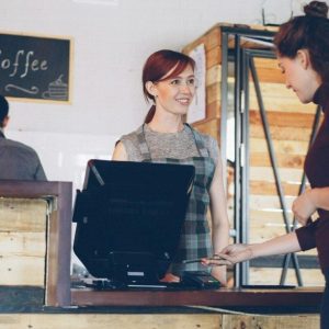 cashier taking tap payment at counter
