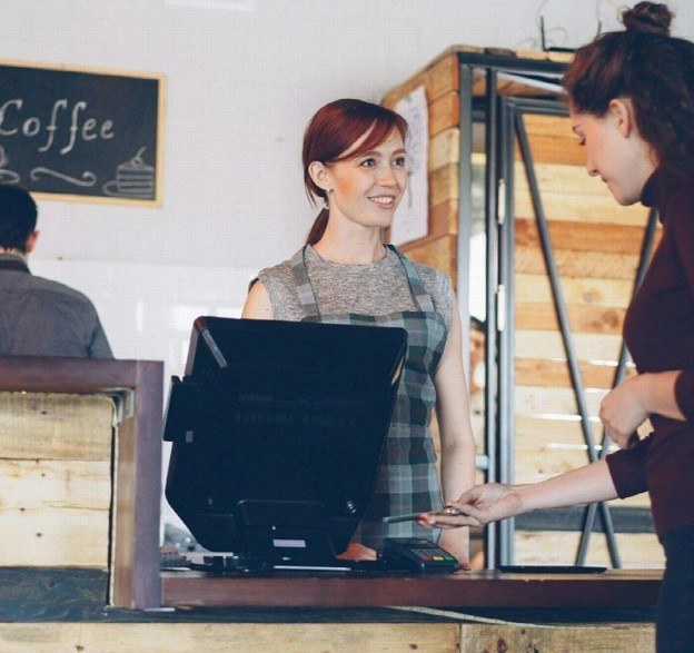 cashier taking tap payment at counter