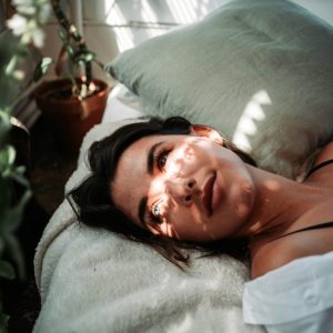 woman in white tank relaxing on a bed