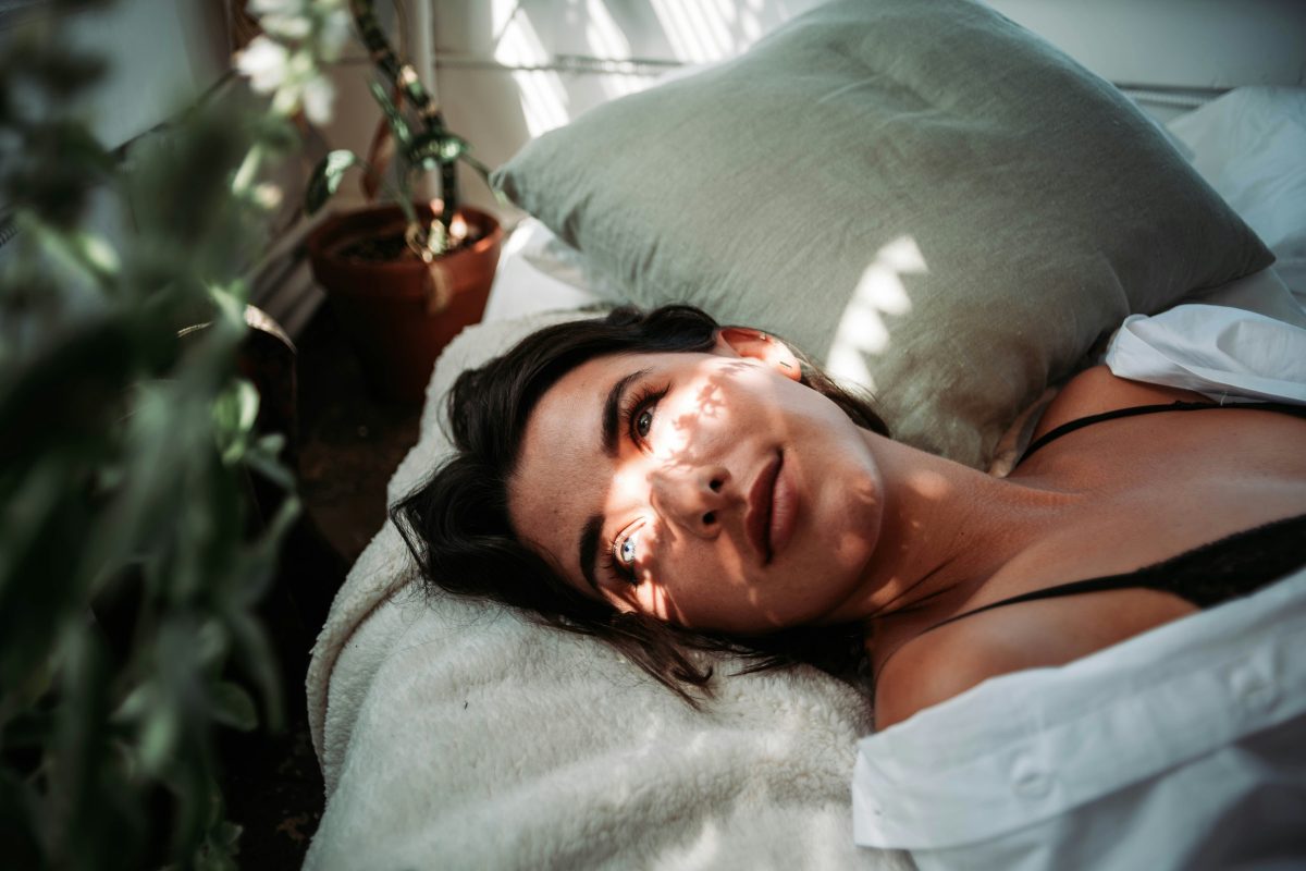 woman in white tank relaxing on a bed