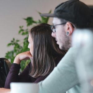 man in white long sleeve shirt sitting beside woman in black shirt