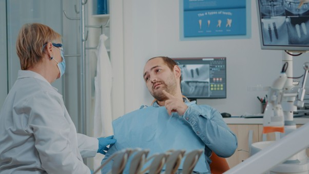 man at dentist pointing at tooth