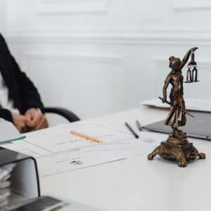 A legal professional's workspace featuring Lady Justice statue, documents, and a laptop.