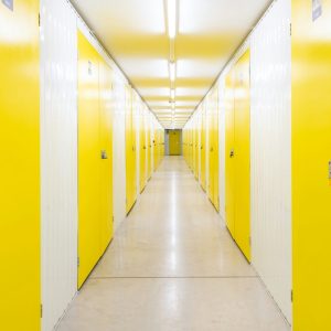 a long hallway with yellow doors on both sides