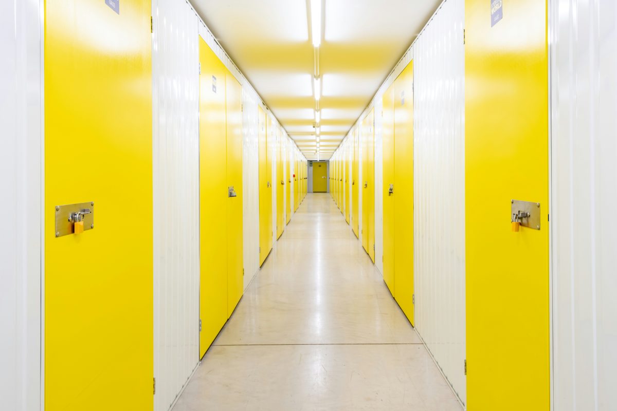 a long hallway with yellow doors on both sides