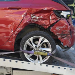 damaged red car on a tow truck