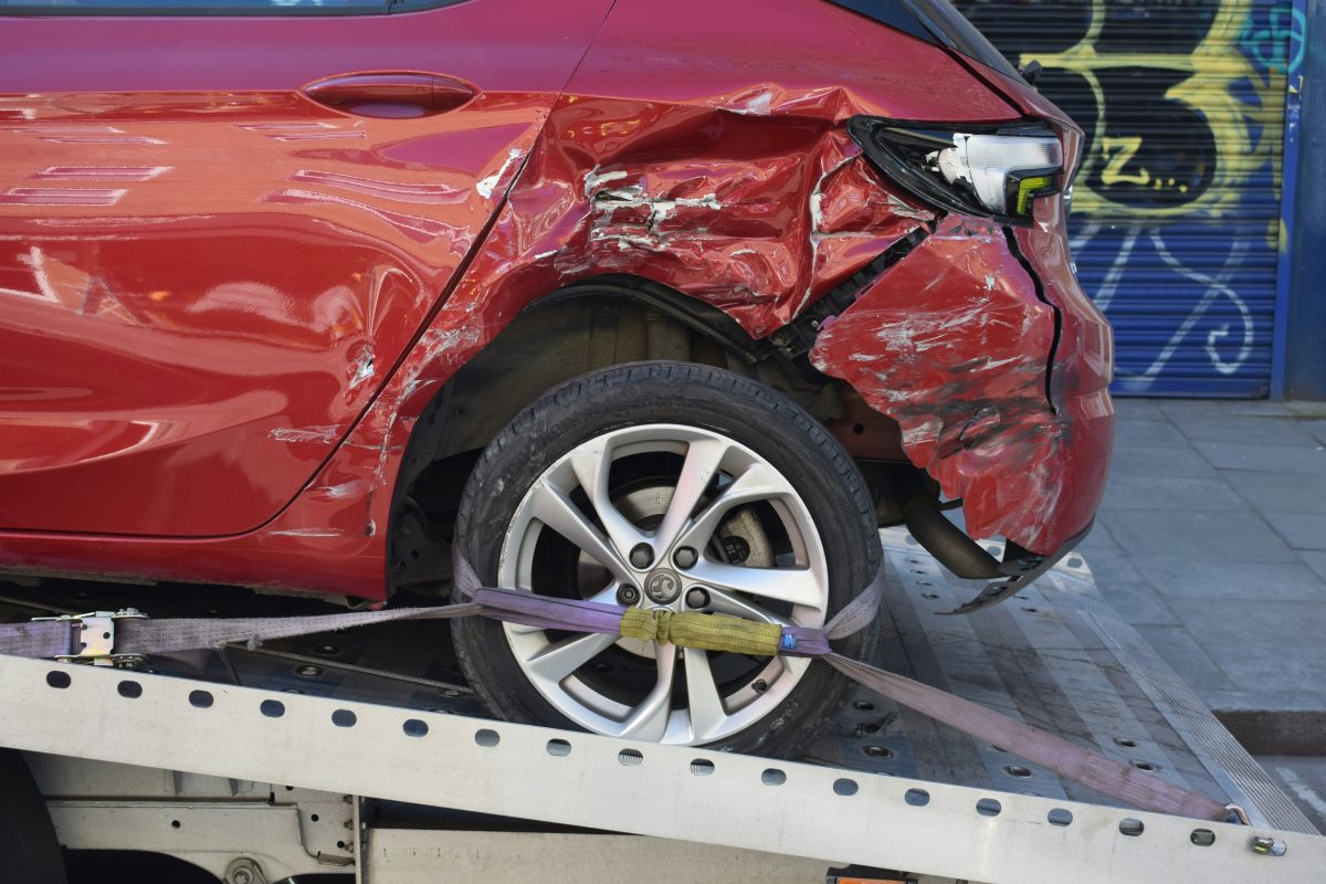 damaged red car on a tow truck