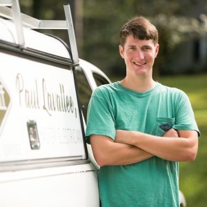 Paul Lavallee standing with arms crossed beside a Lavallee Electrical work truck