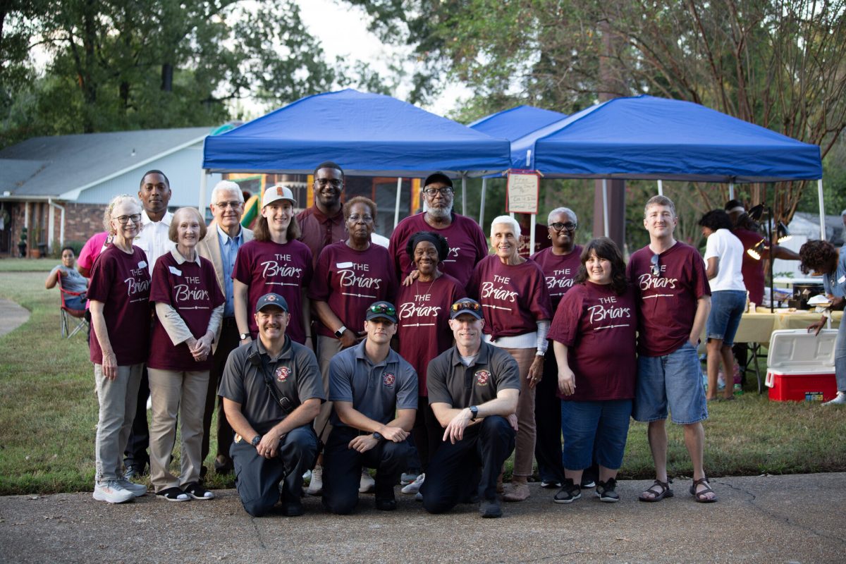 Briars neighbors, City officials and first responders posing together in front of blue tents