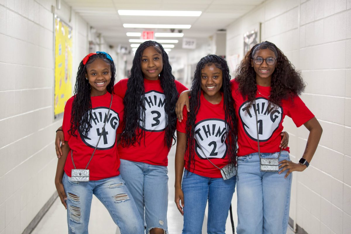 Four Clinton Junior High students in matching red Thing 1 through Thing 4 shirts in a school hallway
