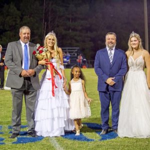 Clinton Christian Academy Homecoming court members and escorts on the football field at halftime
