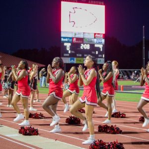 Clinton High School cheerleaders performing on the track during the Homecoming game at night