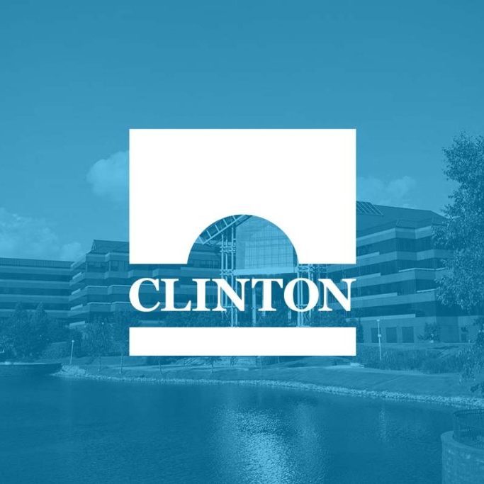 Clinton, Mississippi city logo over a blue-tinted photo of a lakeside office building
