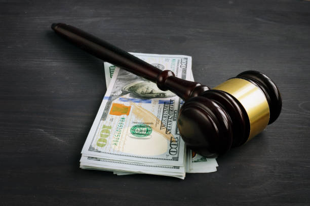 judges gavel on top of hundred dollar bills