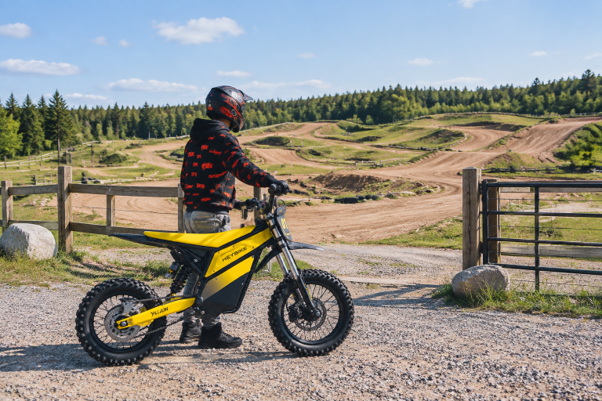 man holding yellow electric dirt bike
