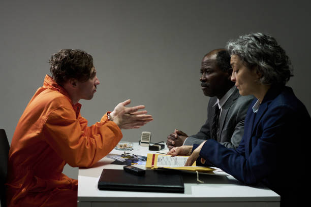 man in orange jumpsuit in interragation room at jail