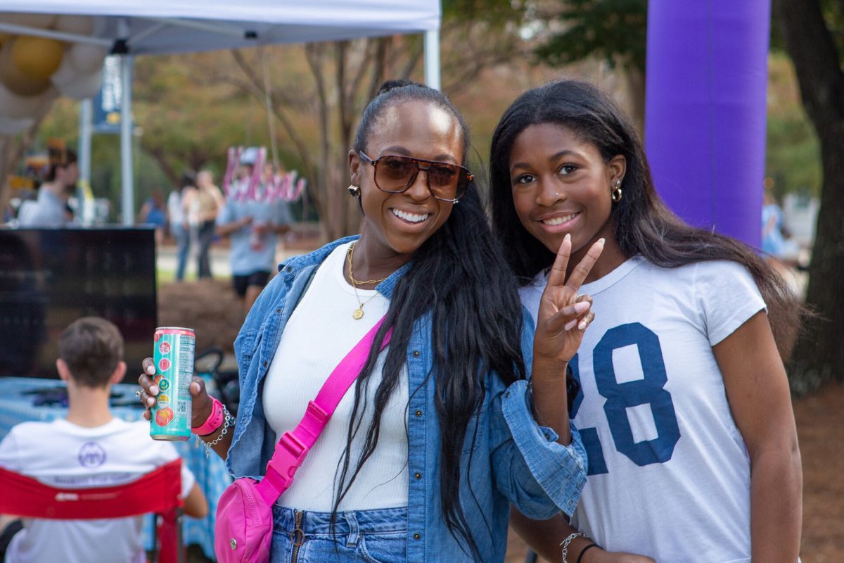 Two women smiling for a photo at an MC homecoming tailgate