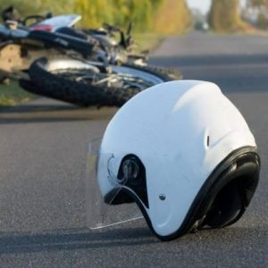 white motorcycle helmet laying on the ground after an accident