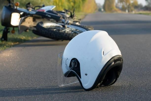 white motorcycle helmet laying on the ground after an accident