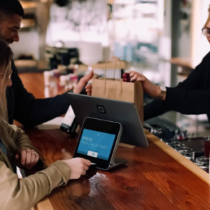 woman using point of sale system for payment at bar