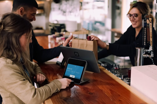 woman using point of sale system for payment at bar