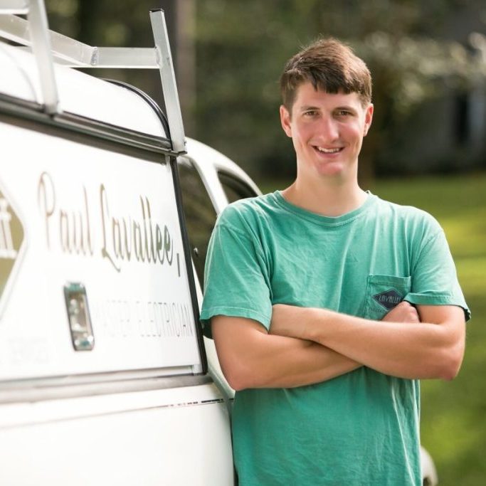 Paul Lavallee standing with arms crossed beside a Lavallee Electrical work truck